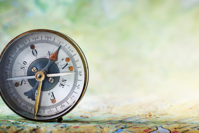 Magnetic old compass on world map.Travel, geography, navigation, tourism and exploration concept background. Macro photo. Very shallow focus.